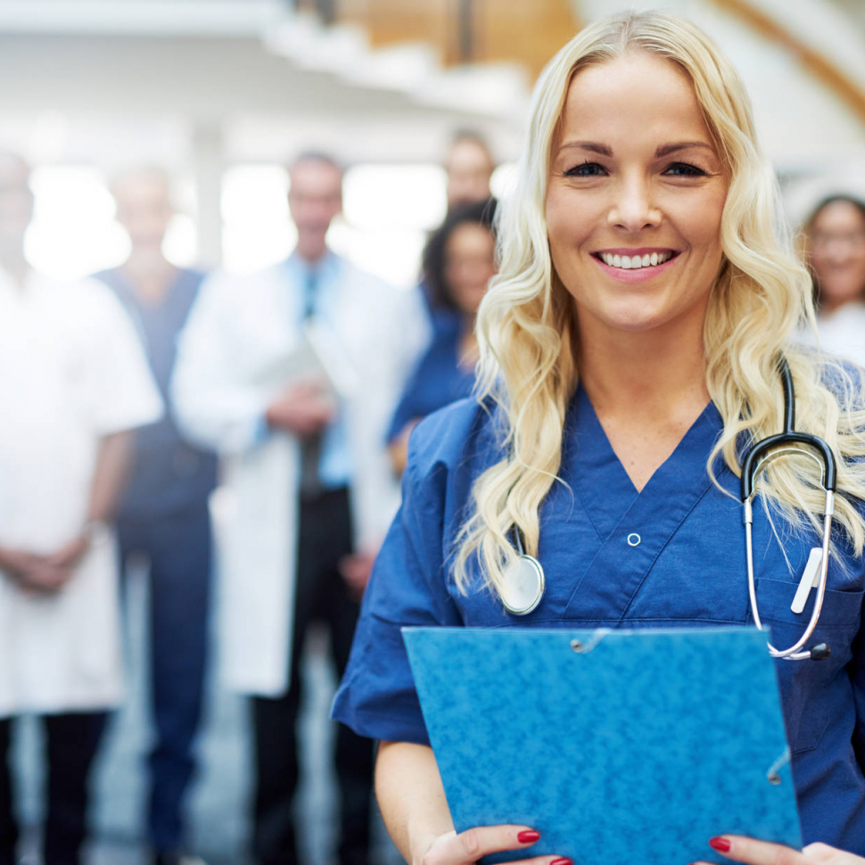 Cheerful blond medic with documents in hospital